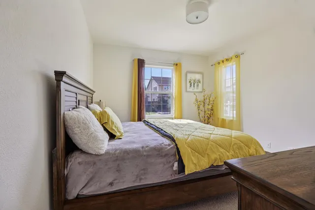 a bed sitting in a bedroom next to a window and a bathroom