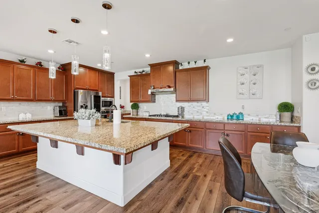 a kitchen with stainless steel appliances granite countertop sink stove top oven and cabinets