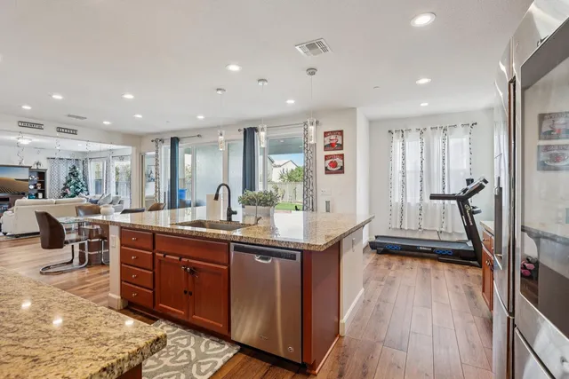 a kitchen with granite countertop a sink a stove and cabinets