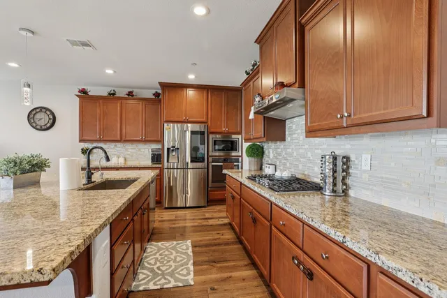 a kitchen with granite countertop a stove and a sink