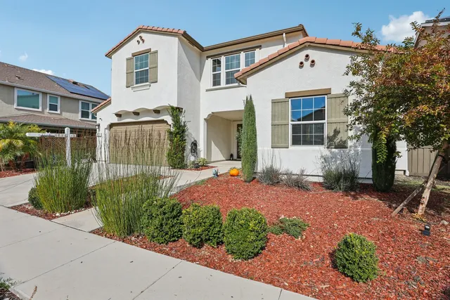 a front view of a house with a yard and outdoor seating