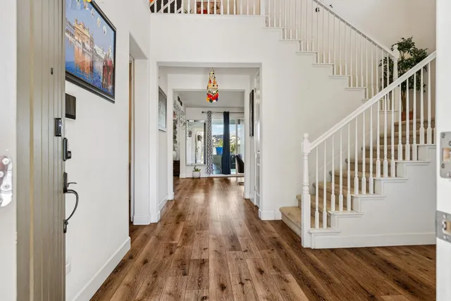 a view of a hallway with wooden floor and stairs