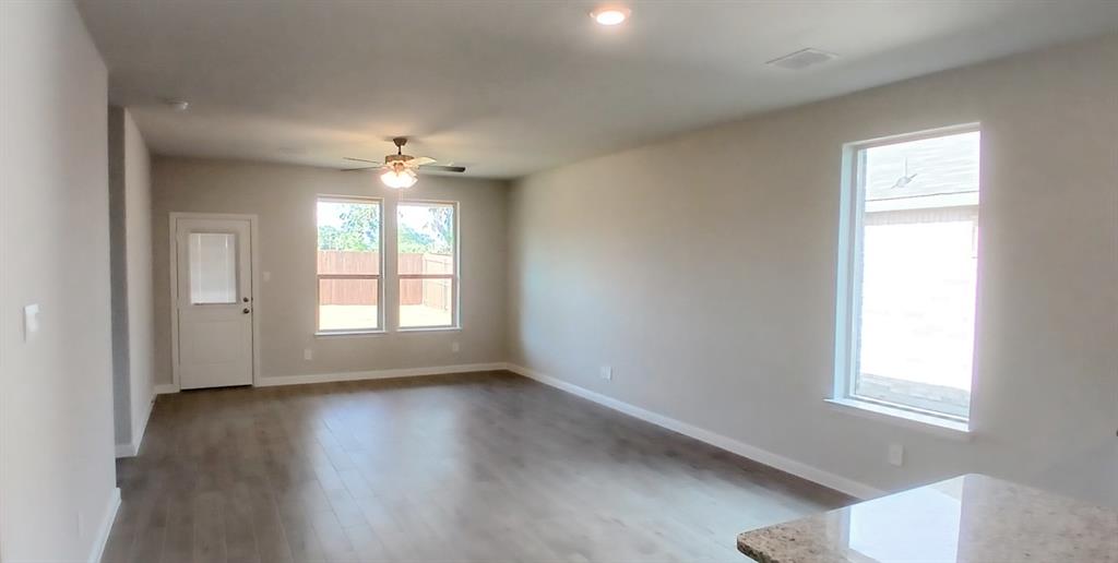 525 Pendleton Avenue Keene, TX 76059 - Photo 2 of 15 a view of an empty room with a window and wooden floor
