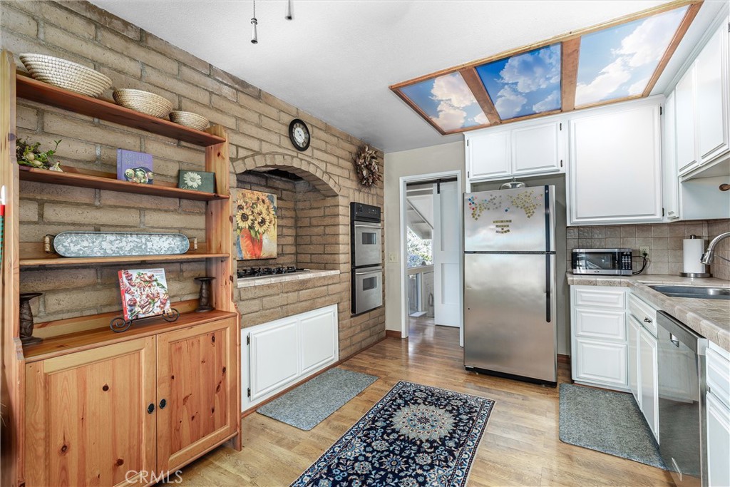 1228 7th Street Los Osos, CA 93402 - Photo 14 of 44 a kitchen with stainless steel appliances kitchen island granite countertop a refrigerator and a stove top oven