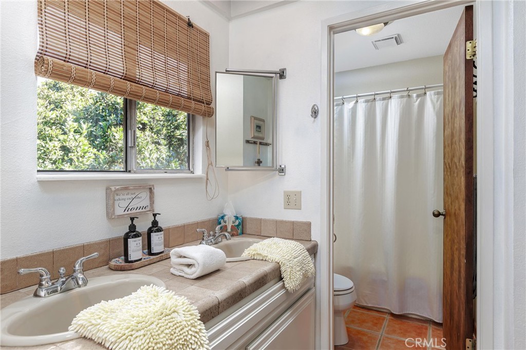 1228 7th Street Los Osos, CA 93402 - Photo 17 of 44 a bathroom with a granite countertop sink and a mirror