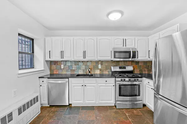 a kitchen with white cabinets and stainless steel appliances