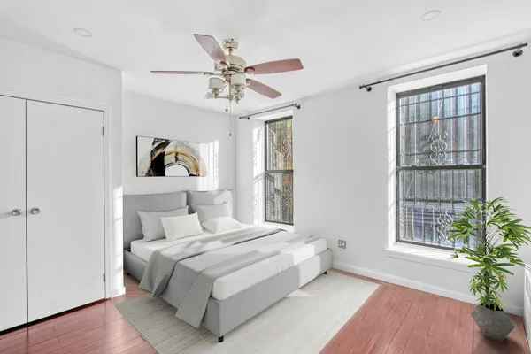 a bedroom with a large bed and a potted plant