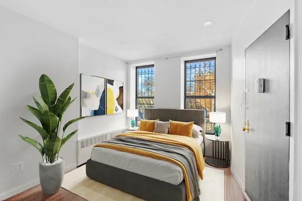 a bedroom with a large bed and a potted plant