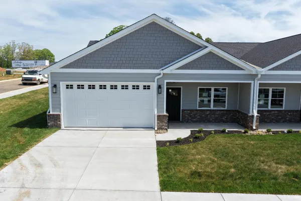 a front view of a house with a yard and outdoor seating