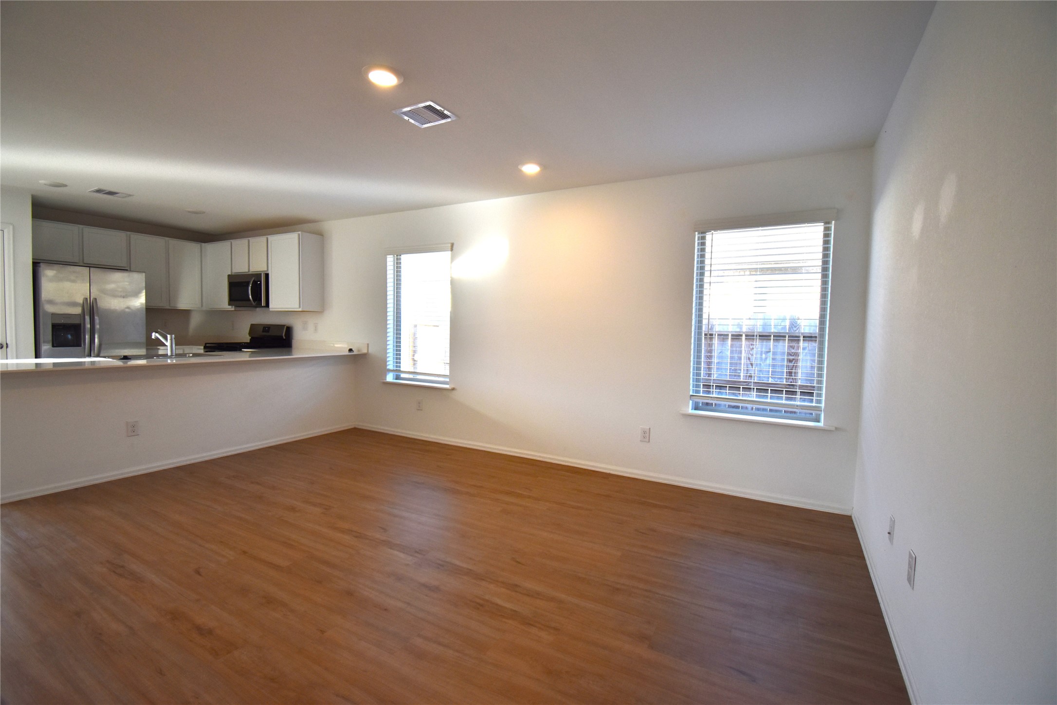 3326 Spanish Oak Lane Rosenberg, TX 77471 - Photo 3 of 24 a view of a kitchen with kitchen island wooden floor and stainless steel appliances