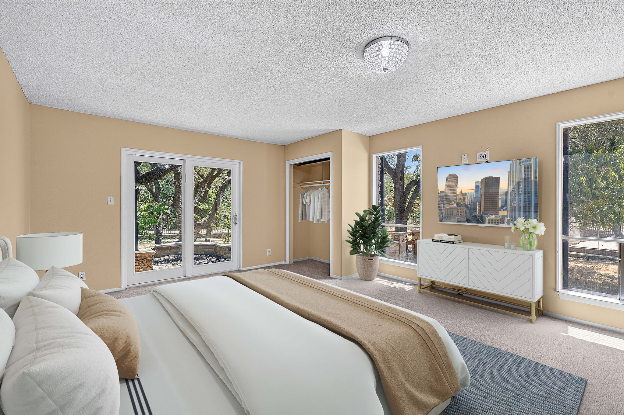 3809 Wyldwood Road Austin, TX 78739 - Photo 15 of 40 Sliding glass doors and large windows bring natural light into this carpeted bedroom.