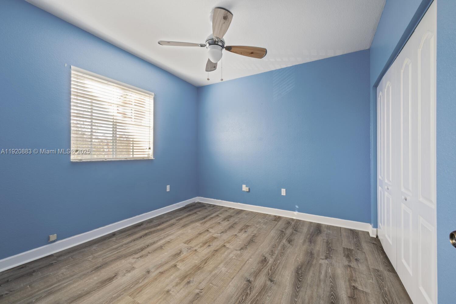 8521 Southwest 214th Terrace Cutler Bay, FL 33189 - Photo 19 of 21 a view of an empty room with wooden floor and a window