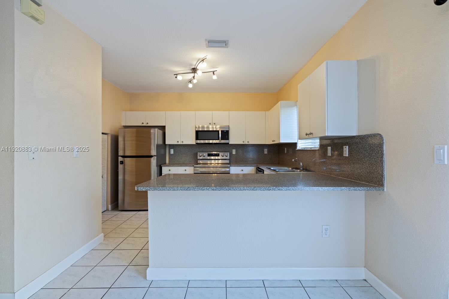 8521 Southwest 214th Terrace Cutler Bay, FL 33189 - Photo 10 of 21 a view of kitchen with stainless steel appliances granite countertop a sink refrigerator and microwave