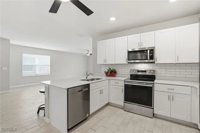 a kitchen with white cabinets stainless steel appliances and sink