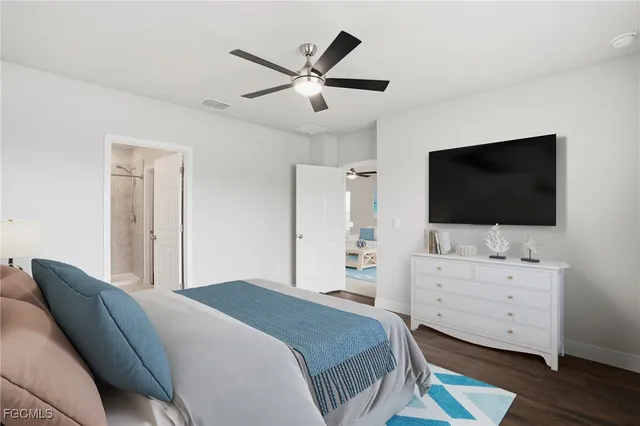 a bedroom with a bed tv and dresser
