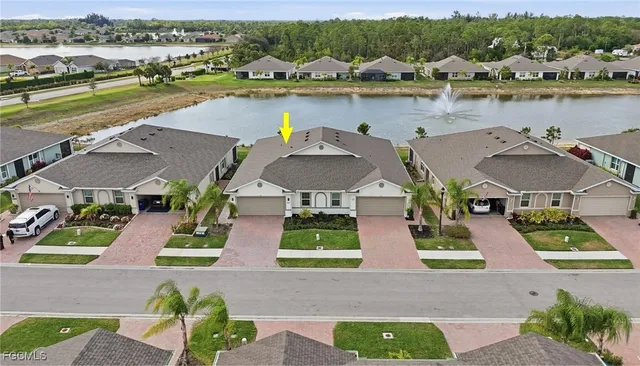 an aerial view of residential houses with outdoor space and lake view