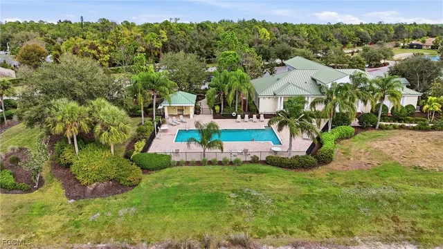 an aerial view of residential houses with outdoor space and trees