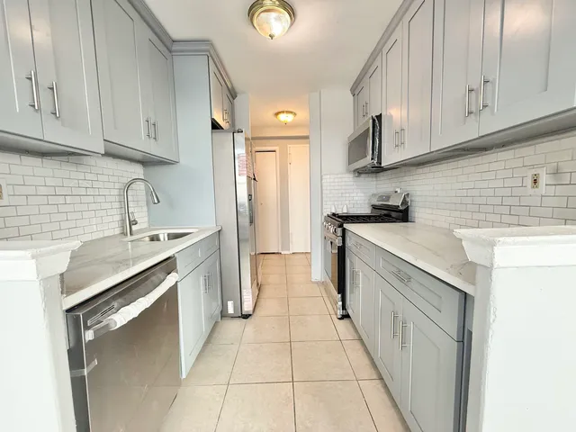 a kitchen with stainless steel appliances granite countertop a sink stove and cabinets