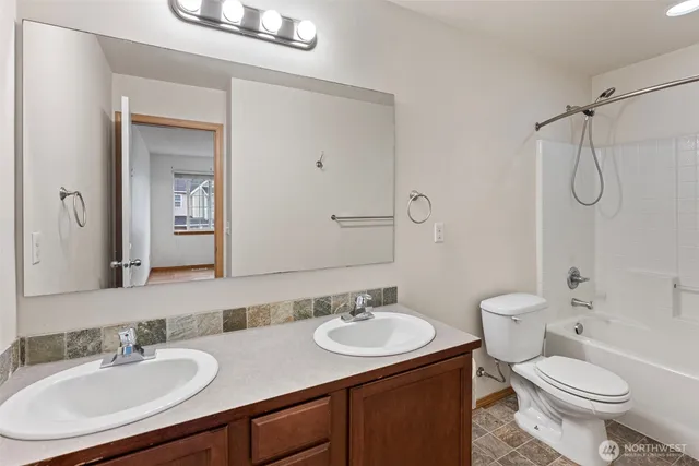 a bathroom with a sink toilet double vanity and shower