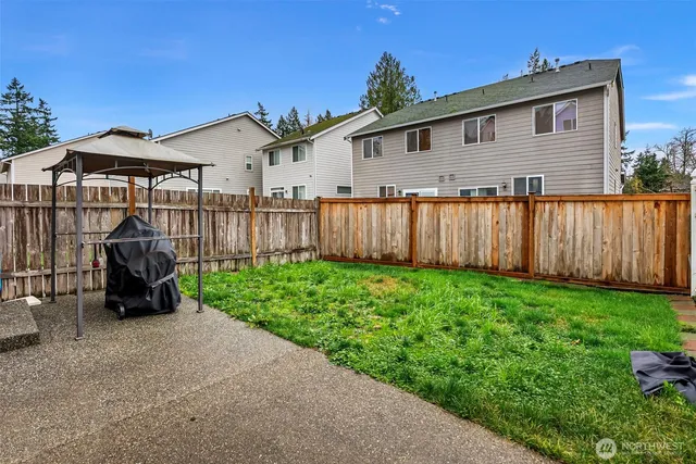 a view of a house with backyard and sitting area