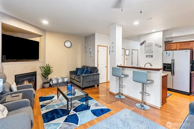 a living room with furniture a flat screen tv and kitchen view