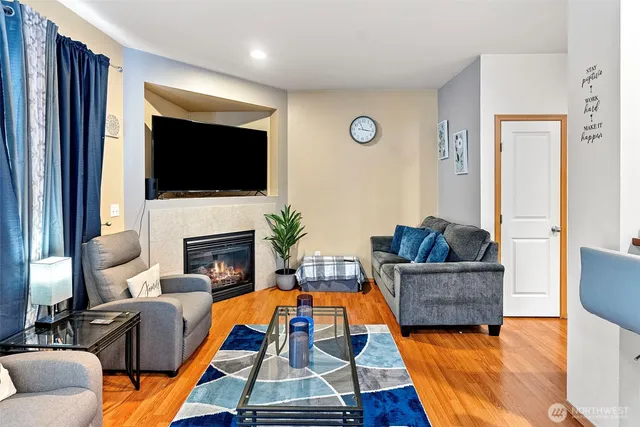 a living room with furniture a flat screen tv and a fireplace