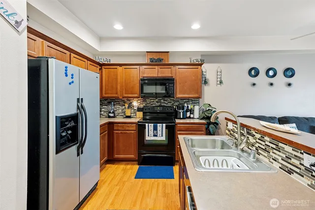a kitchen with stainless steel appliances granite countertop a refrigerator and a stove