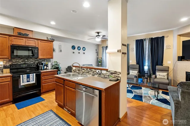 a kitchen with stainless steel appliances granite countertop a stove top oven a sink and a refrigerator