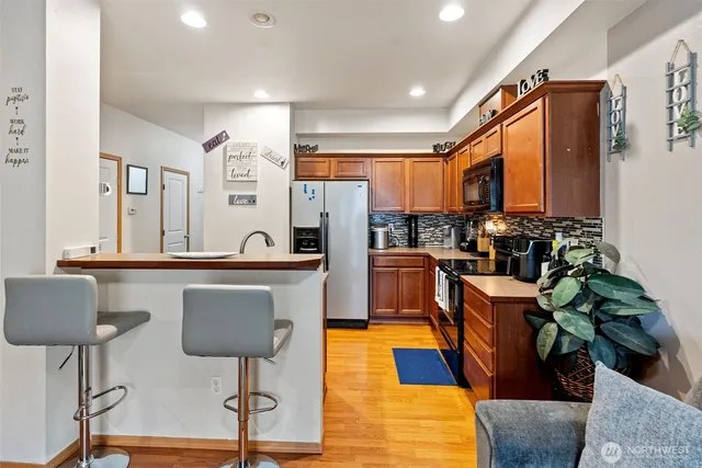 a kitchen with stainless steel appliances granite countertop a refrigerator and a stove