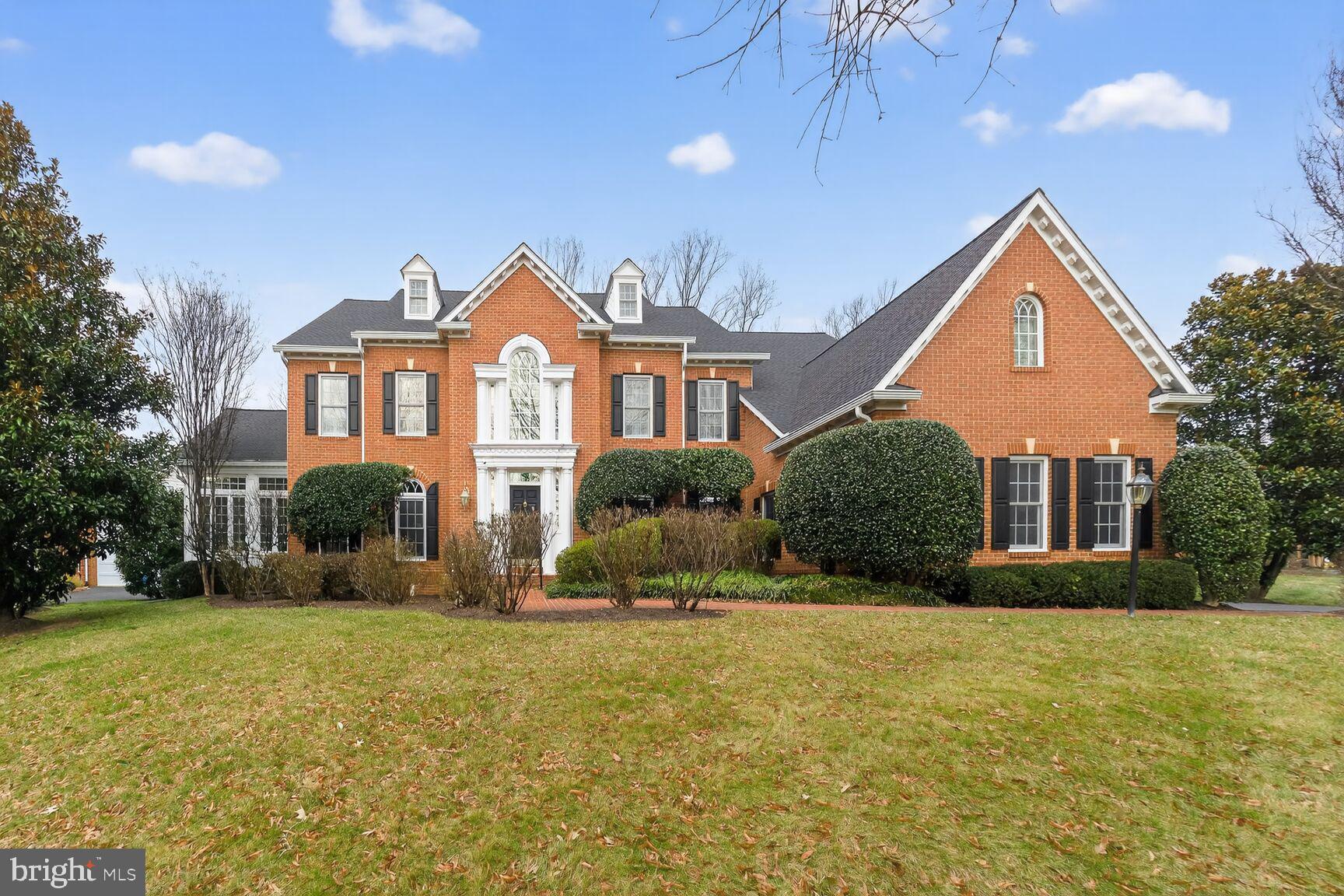a front view of house with yard and trees around