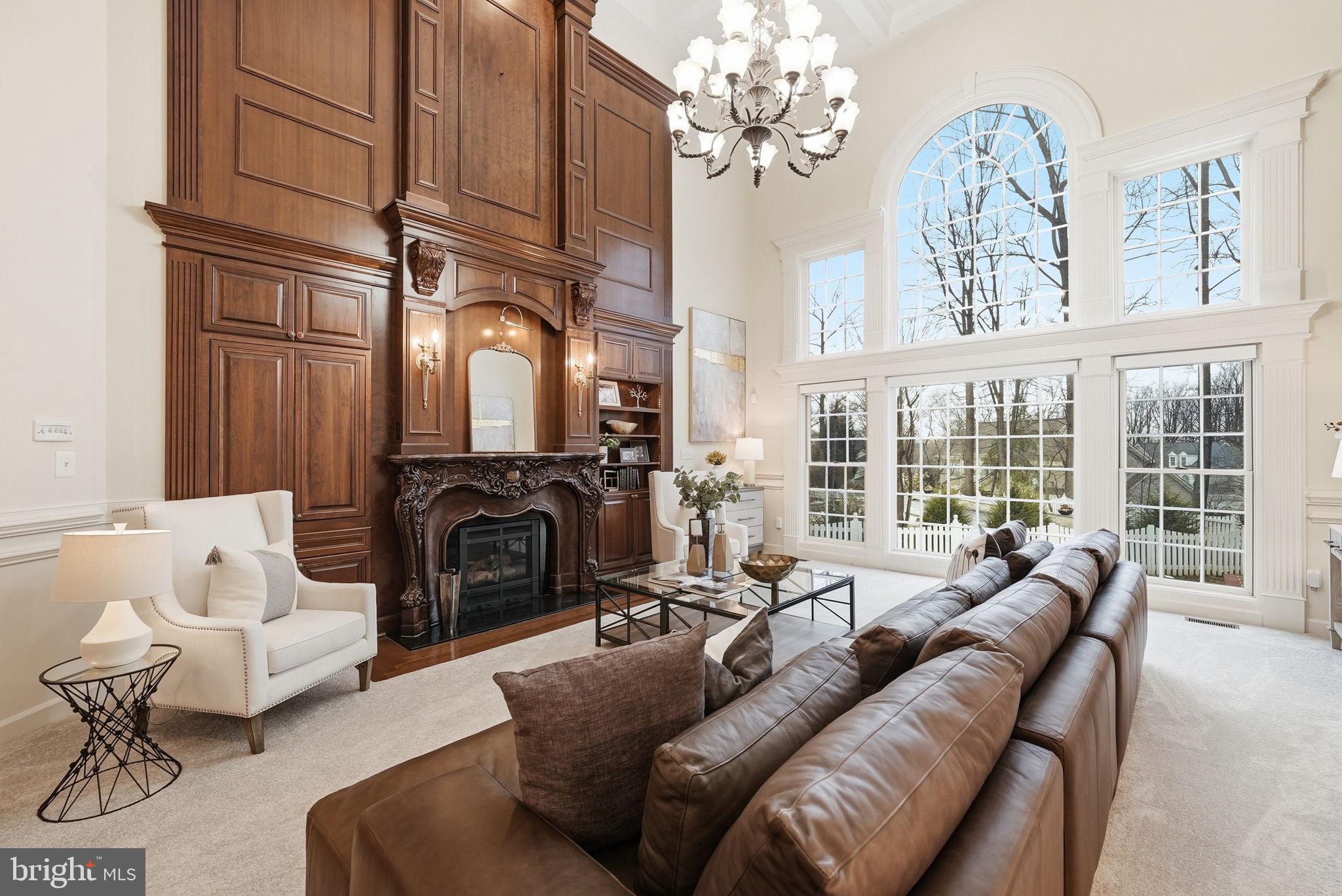 11588 Cedar Chase Road Herndon, VA 20170 - Photo 27 of 81 a living room with furniture a chandelier a fireplace and a large window