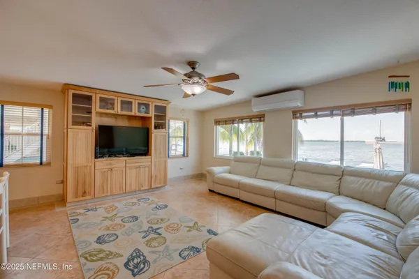 a living room with furniture pool table and chairs