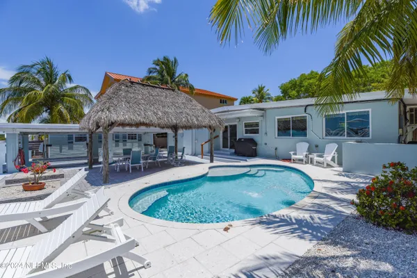a view of a house with swimming pool and sitting area