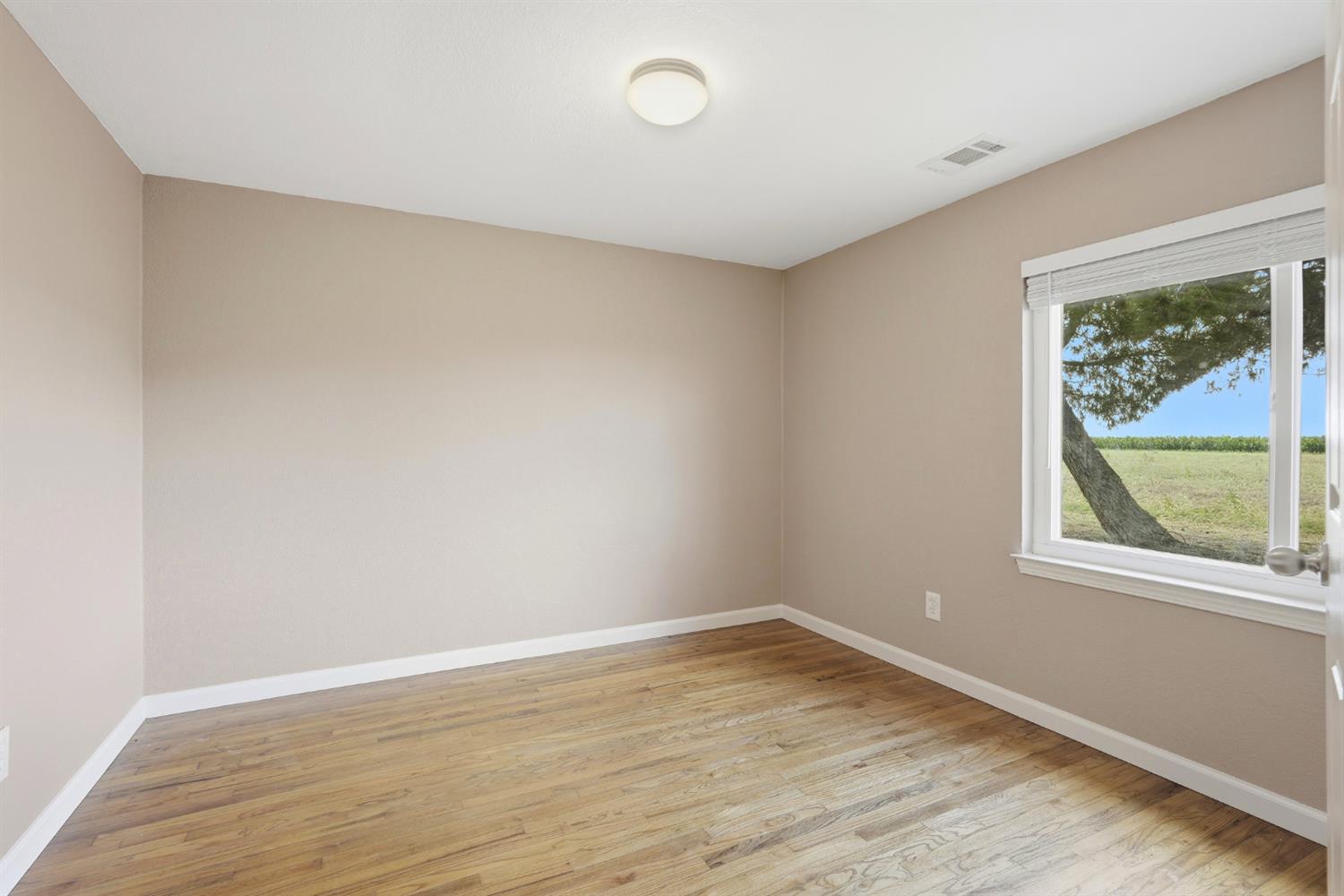 20042 North Ray Road Lodi, CA 95242 - Photo 24 of 63 wooden floor in an empty room with a window