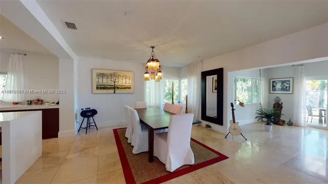 a living room with couches and kitchen view with wooden floor