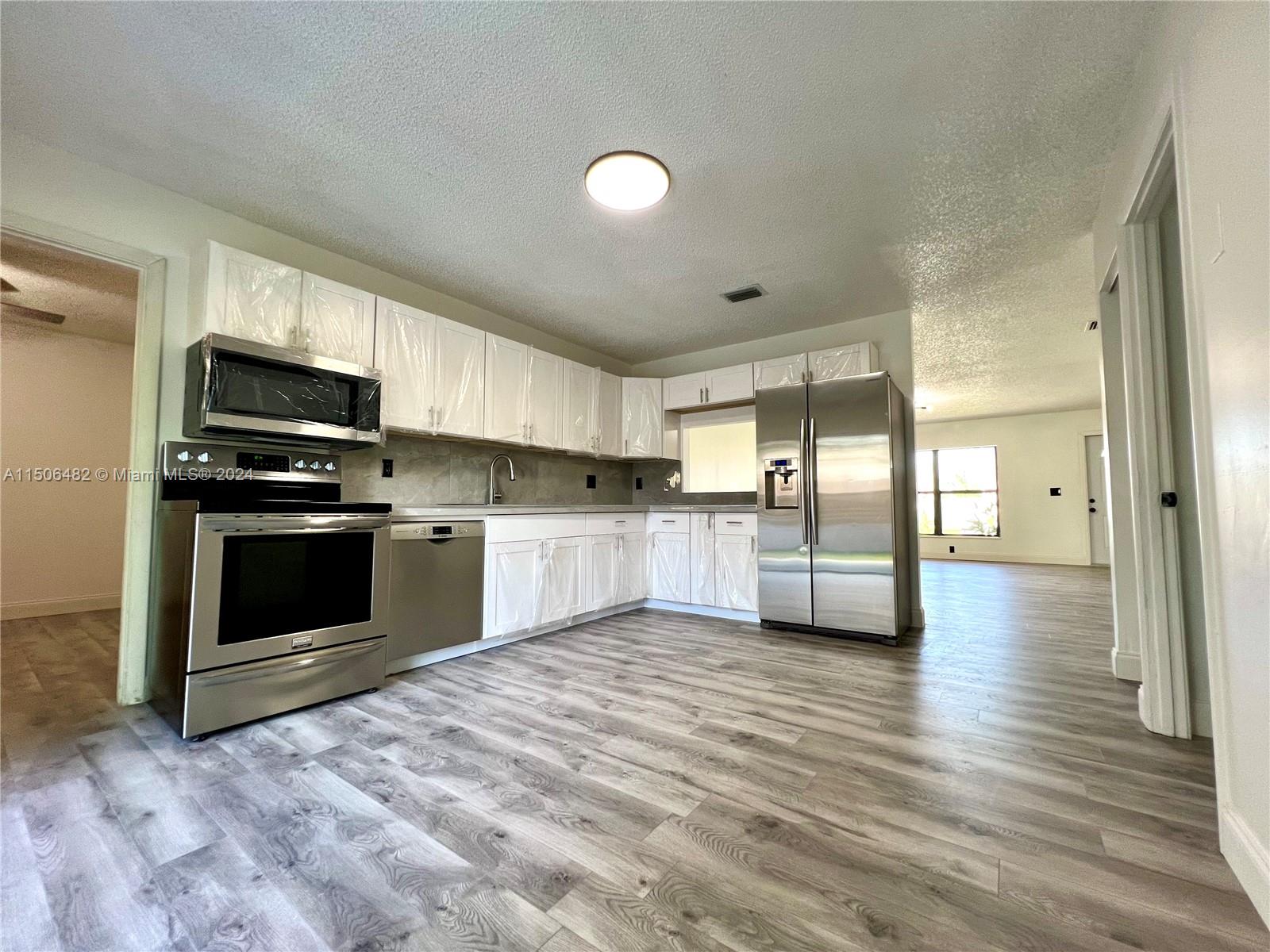 6034 Triphammer Road Lake Worth, FL 33463 - Photo 1 of 10 a view of kitchen with sink and refrigerator