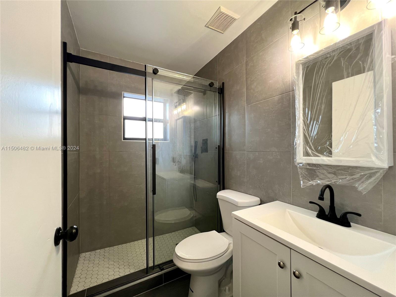 6034 Triphammer Road Lake Worth, FL 33463 - Photo 7 of 10 a bathroom with a sink toilet and shower