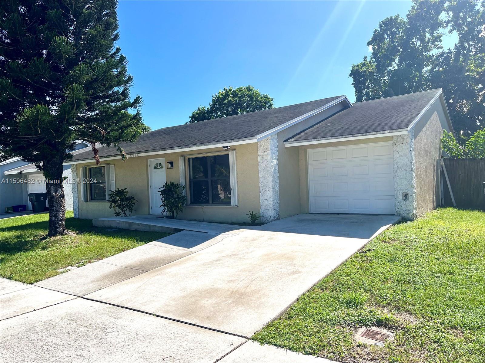 6034 Triphammer Road Lake Worth, FL 33463 - Photo 9 of 10 a front view of a house with a garden and yard