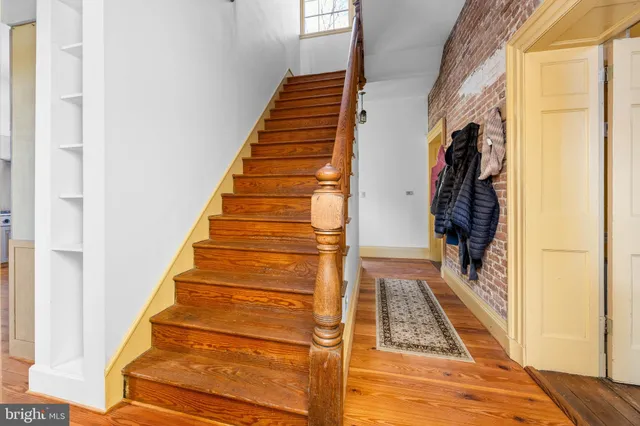 a spacious bedroom with a bed and wooden floor