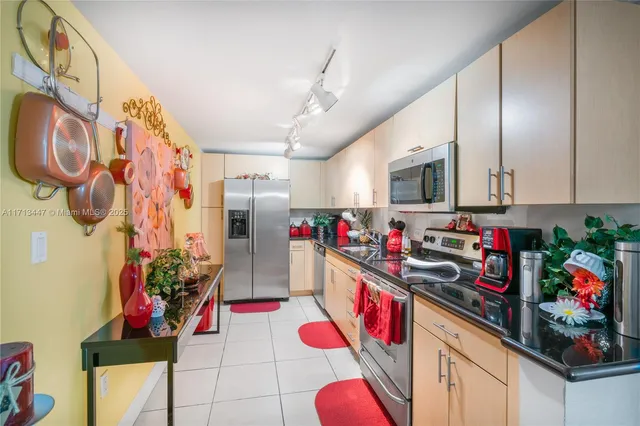 a kitchen with granite countertop lots of clutter and stainless steel appliances