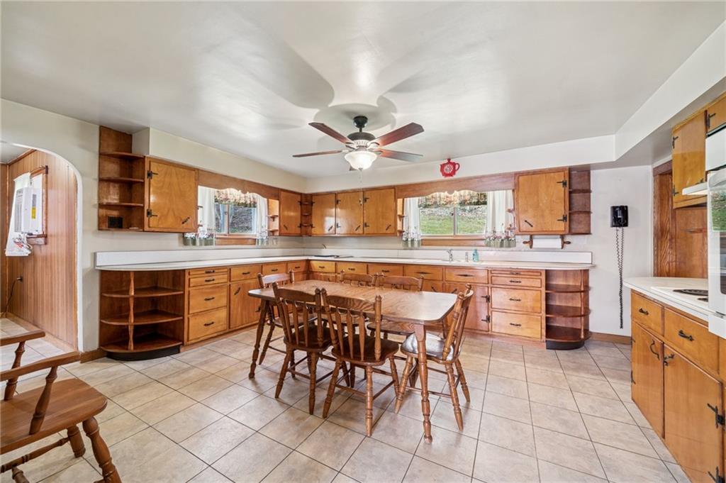 161 Millertown Road Normalville, PA 15469 - Photo 6 of 30 a dining area with stainless steel appliances kitchen island granite countertop a table chairs and a refrigerator