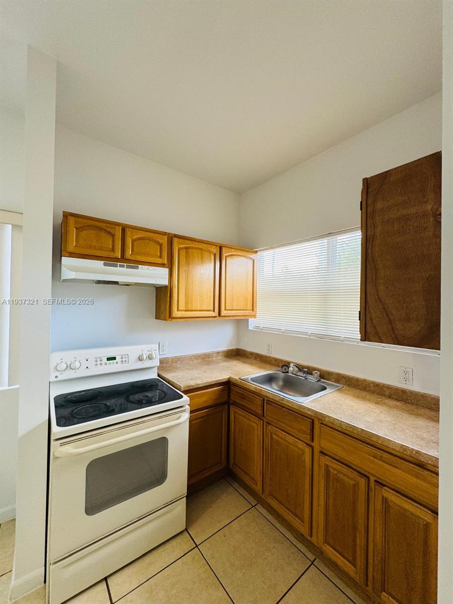 1330 Northwest 5th Street, Unit 1 Miami, FL 33125 - Photo 13 of 15 a kitchen with stainless steel appliances a stove sink and cabinets