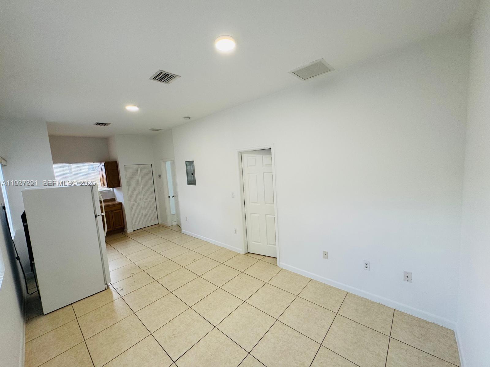 1330 Northwest 5th Street, Unit 1 Miami, FL 33125 - Photo 2 of 15 a view of a kitchen with refrigerator and white cabinets