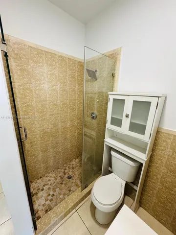 a white toilet sitting next to a shower