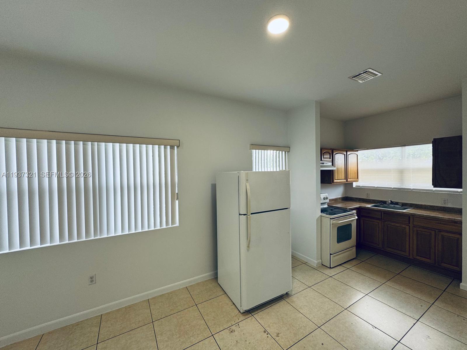 1330 Northwest 5th Street, Unit 1 Miami, FL 33125 - Photo 7 of 15 a kitchen with stainless steel appliances granite countertop a refrigerator and a stove top oven