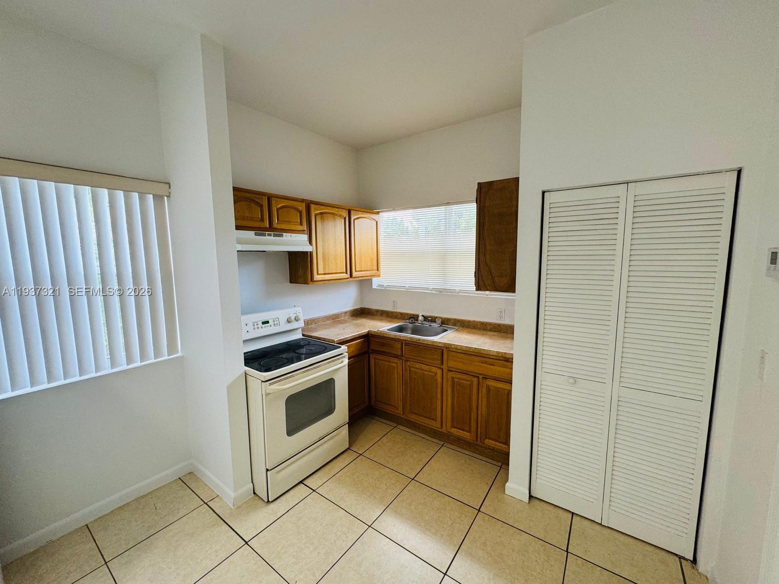 1330 Northwest 5th Street, Unit 1 Miami, FL 33125 - Photo 10 of 15 a kitchen with stainless steel appliances granite countertop a refrigerator and a sink