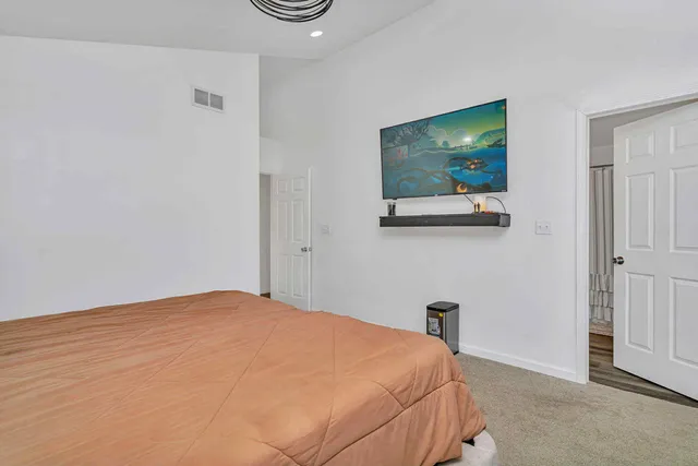 a bedroom with a bed and a flat screen tv