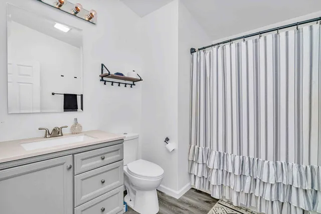 a bathroom with a toilet a sink and a mirror