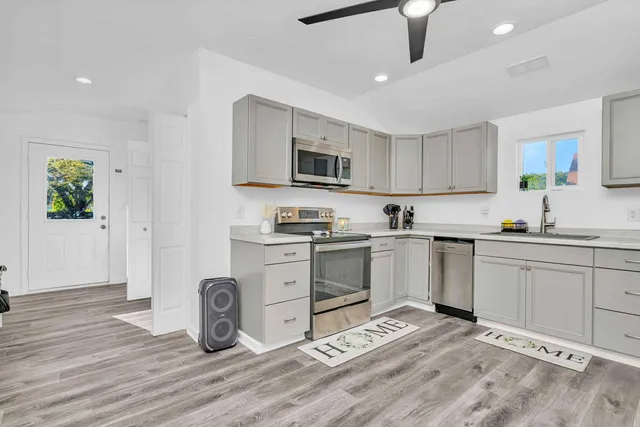 a kitchen with granite countertop a stove a sink and a microwave
