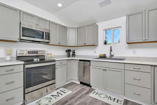 a kitchen with stainless steel appliances granite countertop a sink a stove a microwave oven and cabinets
